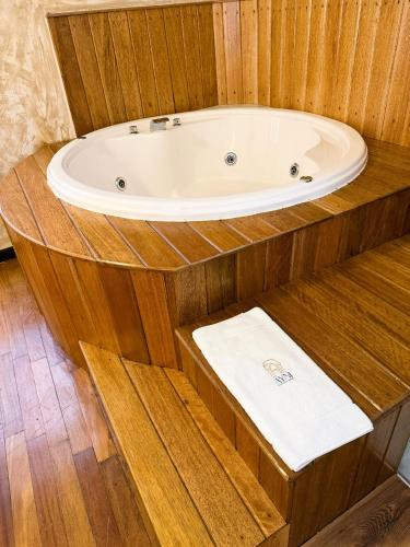 a bath tub in a wooden bathroom with a white towel at Ayni Boutique Hotel in Cusco