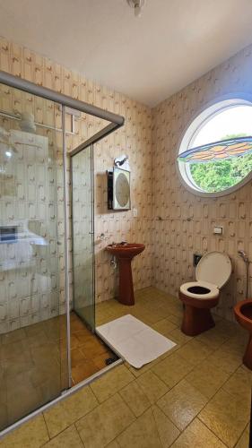 a bathroom with a shower and a toilet and a window at Pousada Villa Real in Sabará