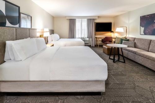 a hotel room with a large bed and a couch at Staybridge Suites Halifax - Dartmouth by IHG in Halifax