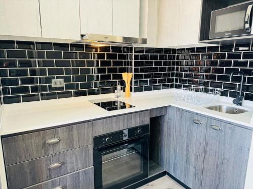 a kitchen with black and white tile on the wall at Terminal de Buses - Centro de Valparaíso in Valparaíso