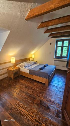 a bedroom with a large bed and a wooden floor at Hnatowa Chata in Wetlina
