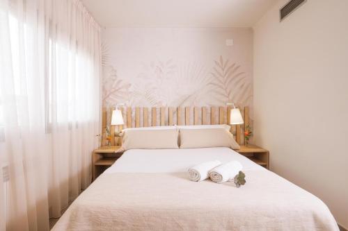 a bedroom with a bed with two towels on it at Apartamentos Castellmar in Castelldefels
