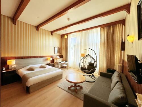 a hotel room with a bed and a couch at Hotel Dordrecht in Dordrecht