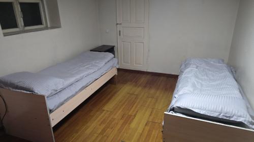 sypialnia z dwoma łóżkami w pokoju z drzwiami w obiekcie BON Hostel w mieście Osz