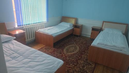 pokój z dwoma łóżkami i dwiema szafkami nocnymi w obiekcie BON Hostel w mieście Osz
