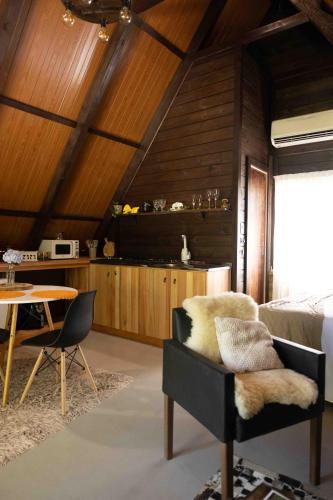 a room with a bed and a table with a chair at Recanto do Rio Chalé na Natureza in Rio dos Cedros