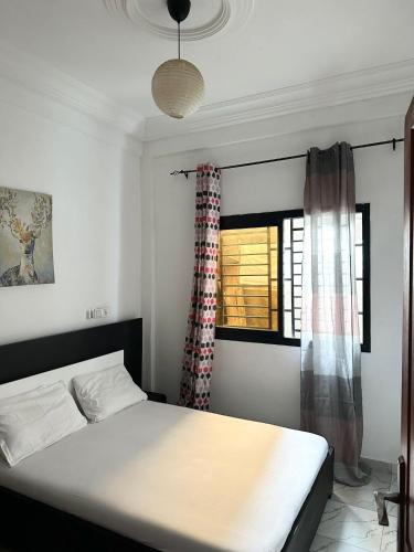 a bedroom with a bed and a window at Residence Life House Makepe bm in Douala