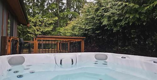 a large white bath tub sitting outside of a house at Hot Tub - Large Fully Enclosed deck - Pet Friendly in Port Renfrew