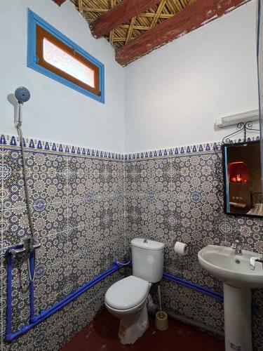 a bathroom with a toilet and a sink at GITE LA GROTTE VALLEE in Aoûtouss
