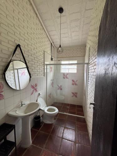 a bathroom with a toilet and a sink and a mirror at Casa 2 Silvia Beatriz in Holambra