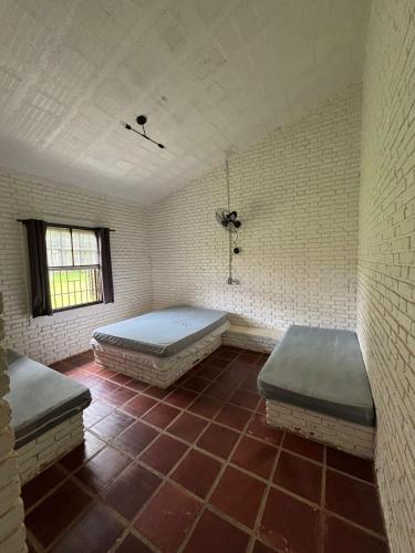 a room with two beds on a tiled floor at Casa 2 Silvia Beatriz in Holambra