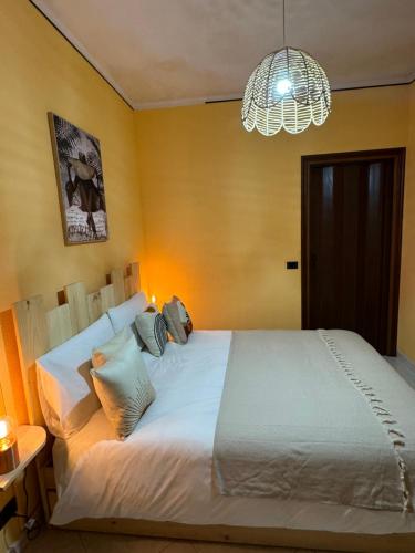 a bedroom with a large white bed and a chandelier at Il Gelso Bianco in Bordighera