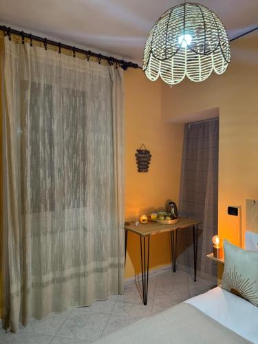 a bedroom with a bed and a table and a chandelier at Il Gelso Bianco in Bordighera