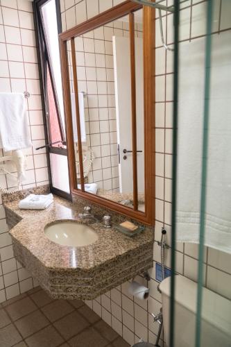 a bathroom with a sink and a mirror at New Life Piracicaba by Atlantica in Piracicaba