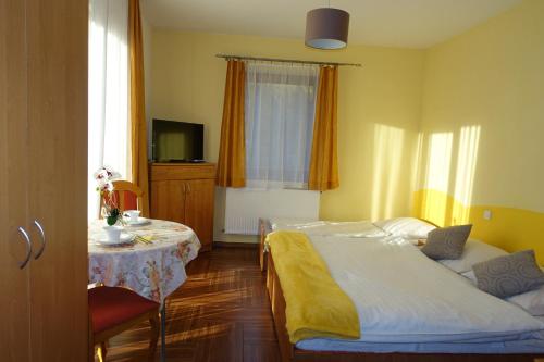 a bedroom with a bed and a table and a television at Apartamenty u Ani in Kudowa-Zdrój