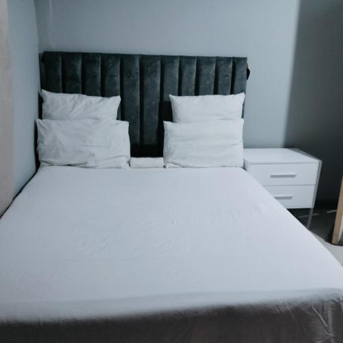 a large bed with white sheets and pillows at N2 Village BnB in Hadi