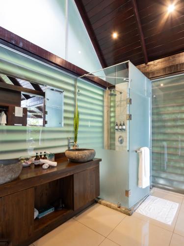 a bathroom with two sinks and a glass shower at Oxygen Jungle Villas & Spa in Uvita