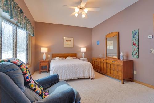 a bedroom with a bed and a couch and a mirror at Lake Access w/ Dock! Hayward Cabin Hideaway in Hayward