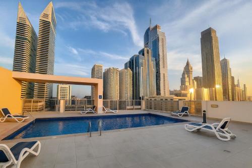 a swimming pool on top of a building with a city skyline at Deluxe Apartments Near WTC and Sheikh Zayed in Dubai
