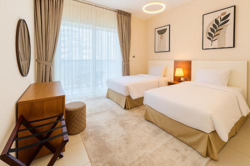 a hotel room with two beds and a window at Deluxe Apartments Near WTC and Sheikh Zayed in Dubai