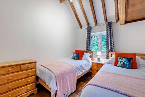 a bedroom with two beds and a dresser and a window at 4 Bed in Flimwell oc-g30190 in Ticehurst