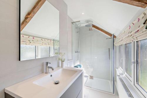 a white bathroom with a sink and a shower at 4 Bed in Flimwell oc-g30190 in Ticehurst