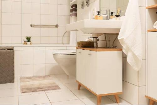 a white bathroom with a sink and a toilet at RegioStyle-Apartment-mit-Meerblick-Balkon-Strand in Eckernförde
