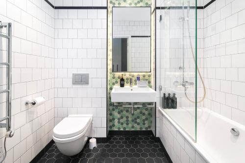 a bathroom with a toilet and a sink and a tub at Cozy and Spacious Central London room in Canary Wharf Flat with a City View & a Private Bathroom in London