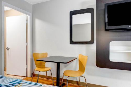 a room with a table and two chairs and a mirror at Motel 6 - Motel 6 Portland, OR - Downtown in Portland