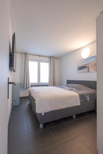 a bedroom with a bed and a television in it at Appartement Wim in Blankenberge