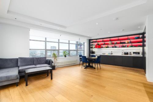 a living room with a couch and a table at Cozy and Spacious Central London room in Canary Wharf with a City View & a Private Bathroom in London