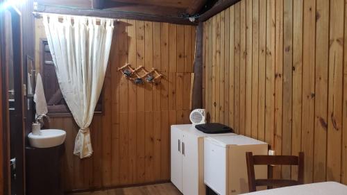a bathroom with a small refrigerator and a sink at Holo Pousada Vale Encantado in Rancho Queimado