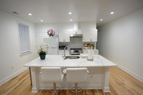 a kitchen with white cabinets and a large white island at Spacious and Brand New Apartment in Point Breeze - Prime Location in Philadelphia