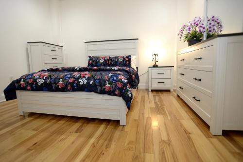 a bedroom with a bed and two dressers at Spacious and Brand New Apartment in Point Breeze - Prime Location in Philadelphia