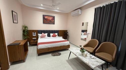 a bedroom with a bed and a table and chairs at Hotel Advika in Kaithal