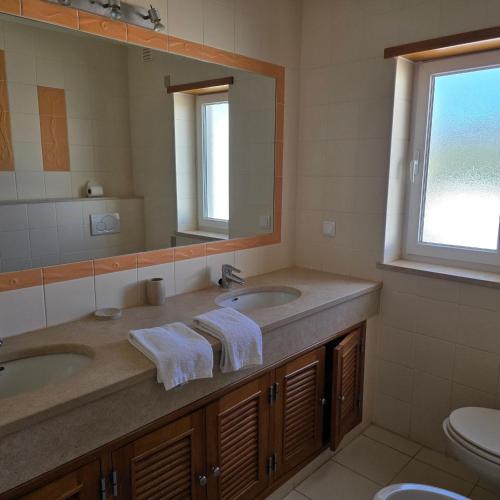 a bathroom with two sinks and a large mirror at Casa Azul in Luz