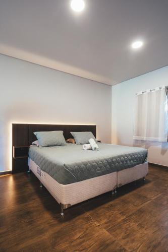 a bedroom with a large bed in a room at Paineira Vila Flat in Paraisópolis