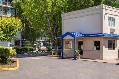 a small building with a blue roof in a parking lot at Motel 6 - Motel 6 Portland, OR - Downtown in Portland