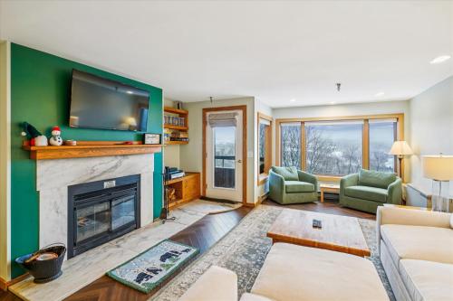 a living room with a fireplace and a flat screen tv at Highridge B14 Enjoy the view ski back trail shuttle service sports center in Killington