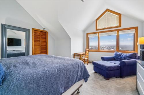 a bedroom with a blue bed and a chair and window at Highridge B14 Enjoy the view ski back trail shuttle service sports center in Killington