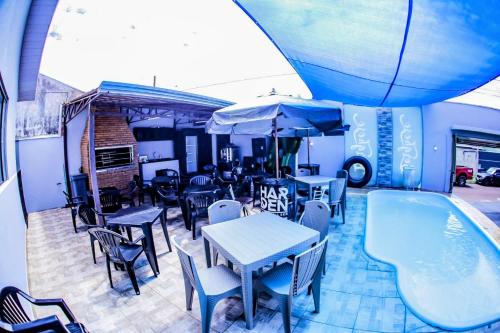 a patio with tables and chairs and a swimming pool at Casa grande com piscina área gourmet in Cascavel