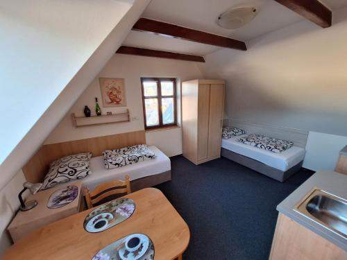 a small room with two beds and a table at Penzion U Vorlíčků in Jablonné nad Orlicí