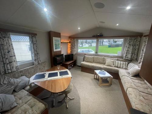 a living room with a couch and a table at 26 The Green Captains Cabin in Crantock