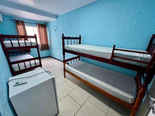 a room with two bunk beds and a refrigerator at Sol e Mar BC in Balneário Camboriú