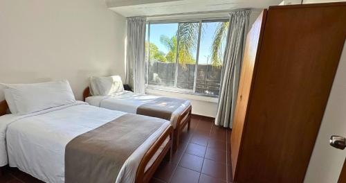 a hotel room with two beds and a window at Aguasol Hotel Termal in Termas del Daymán