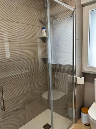 a shower with a glass door in a bathroom at Casa do práctico in Foz