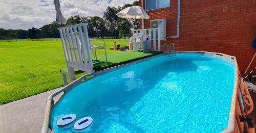 a swimming pool with two chairs and a yard at Hunter Valley Family & Pet friendly Self Contained Accommodation in Mulbring