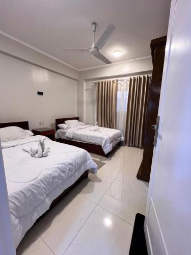 a hotel room with two beds and a window at The Nile Paradise in Al Aqālitah