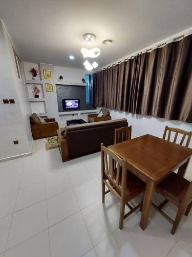 a living room with a table and a couch at إقامة المول in Fort de lʼEau
