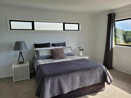 a bedroom with a large bed and a window at Whangaroa Casa Roca House in Kaeo